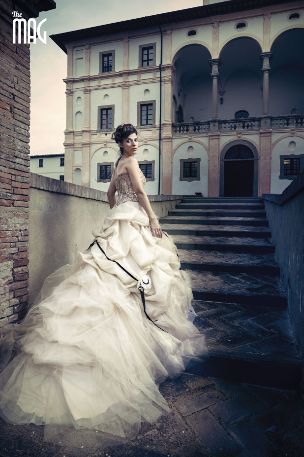 Fotografia di Lucia Rossi in abito da cerimonia mentre sale le scale a Villa Magherini Graziani