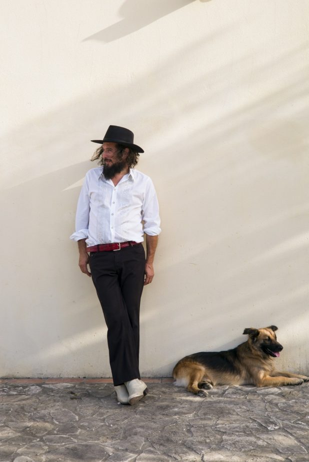 Vinicio Capossela posa appoggiato al muro con un cane