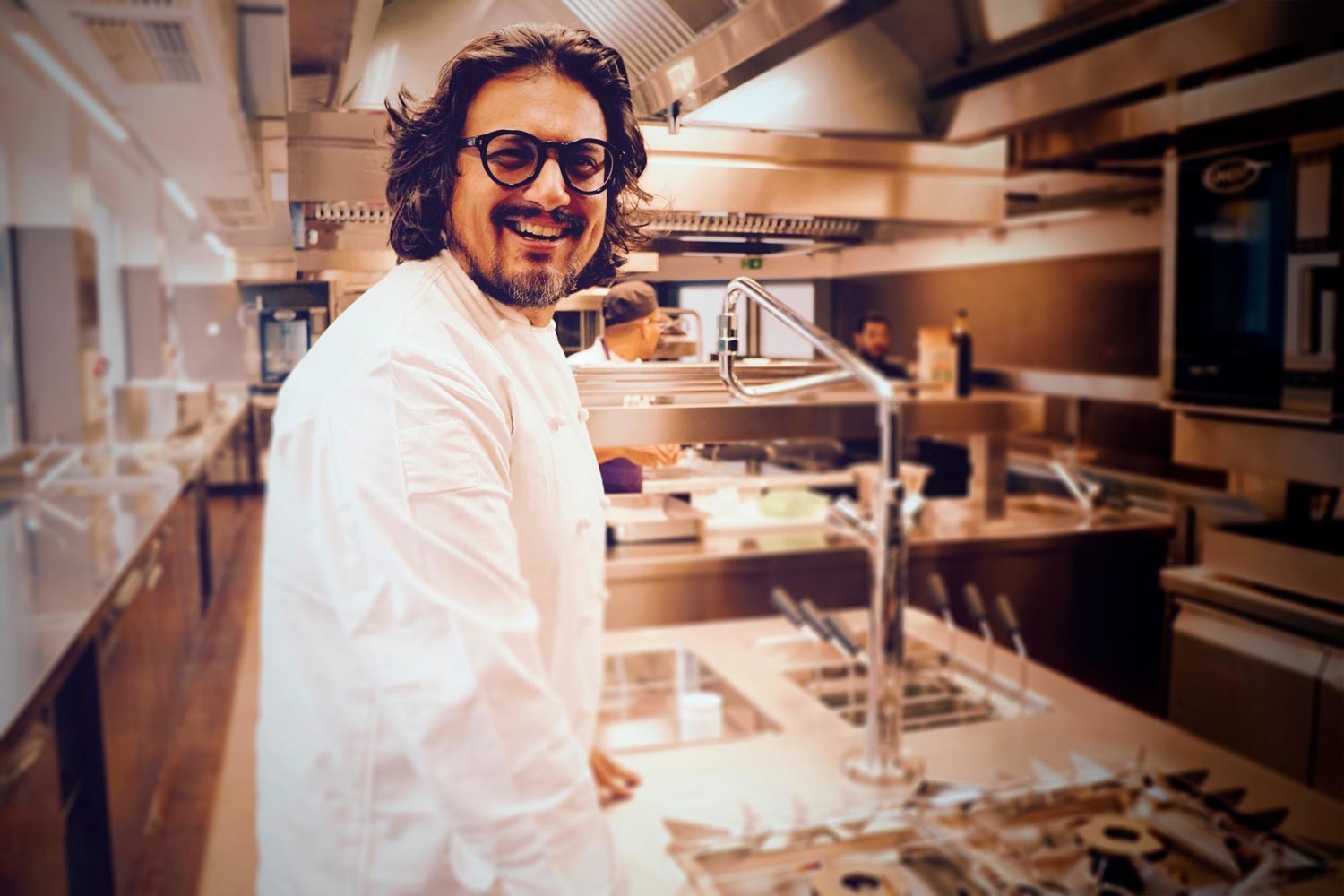 Alessandro Borghese sorridente mentre cucina